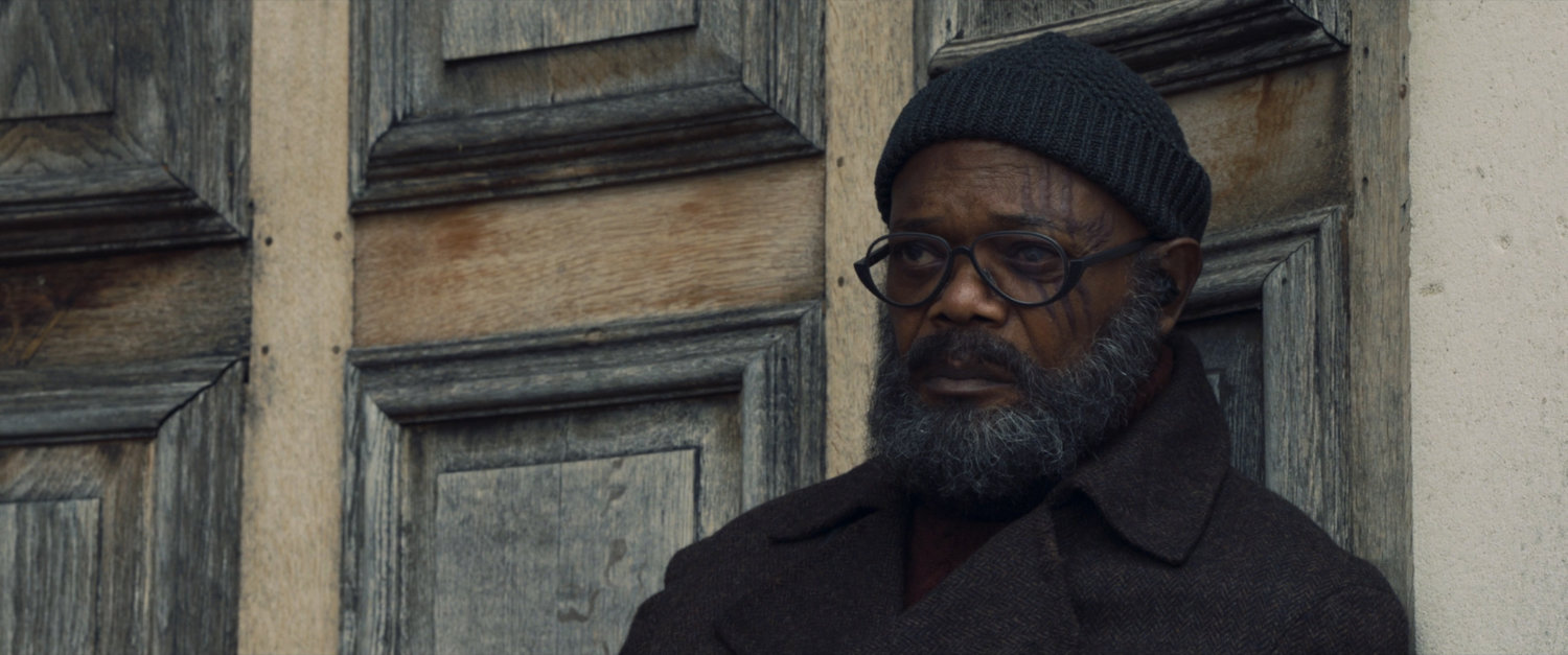 Medium shot of Nick Fury against wooden wall.