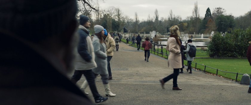 G'iah walking through a Russian park with crowds around her.