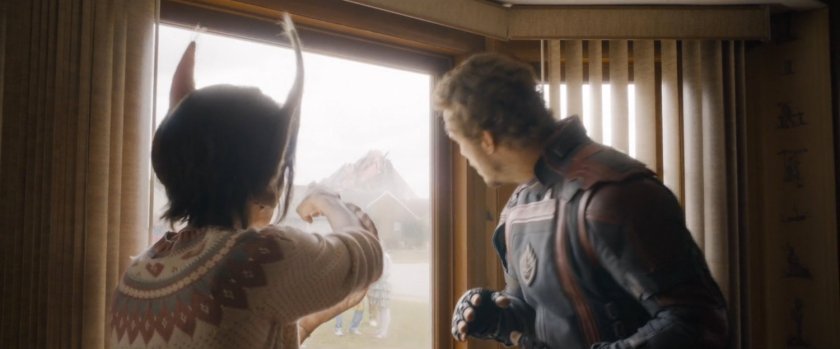 A female humanimal points Star-Lord towards a large building in the distance.