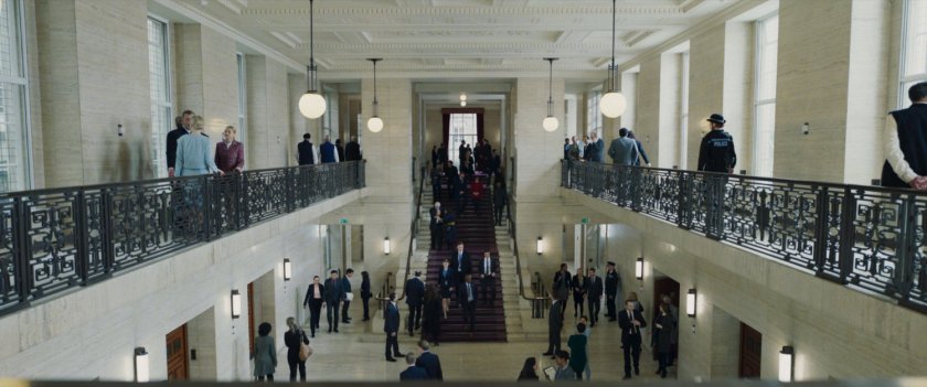 Crowds on a large staircase inside of government offices in London.
