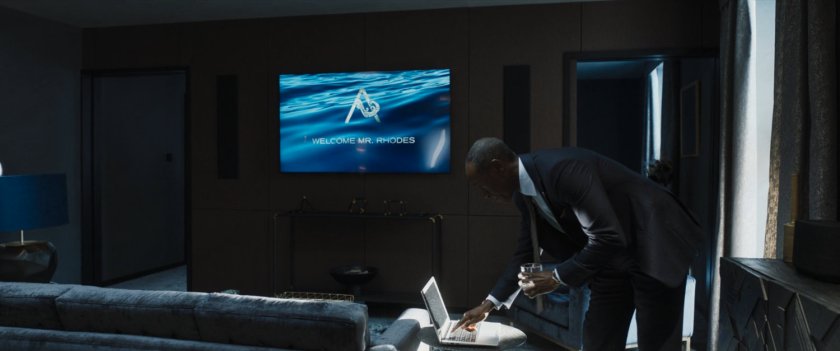 Rhodey checks his laptop in a Hotel suite in London.