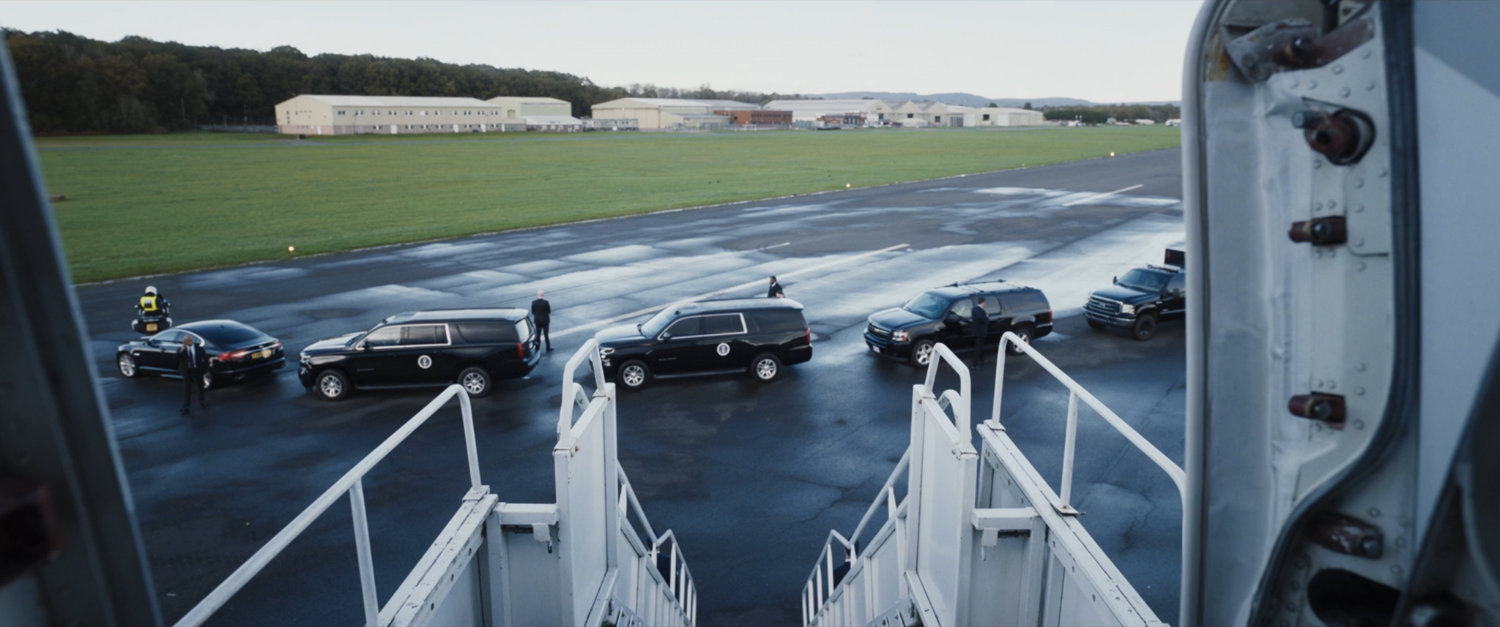 A presidential motorcade on a tarmac as seen from Air Force One.