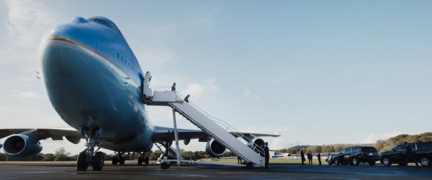 President Ritson descends the stairs of Air Force One to the motorcade below.