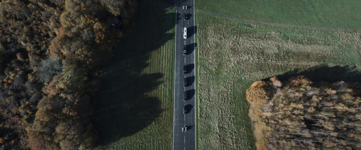 Aerial view of a presidential motorcade on a highway.