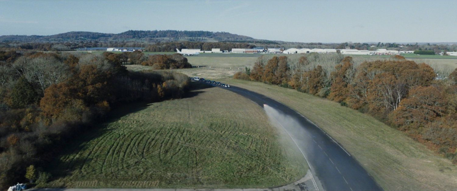 Aerial view of a presidential motorcade on a highway.