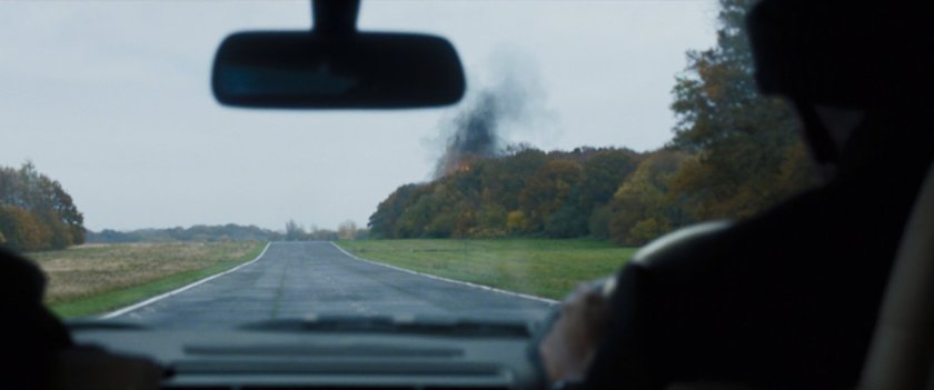 POV of explosion behind tress as seen from Fury's SUV.