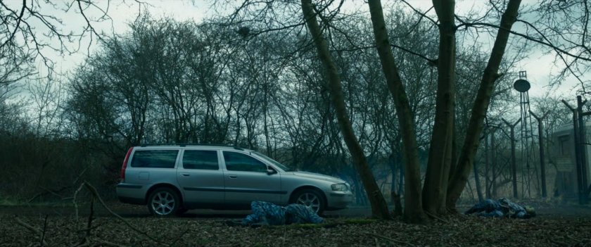 A car stopped outside the New Skrullos gate and guard post, with two dead guards.