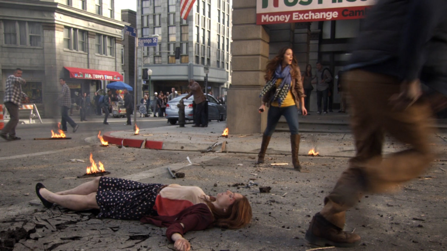 Skye stands over unconscious woman on debris strewn East Los Angeles street.