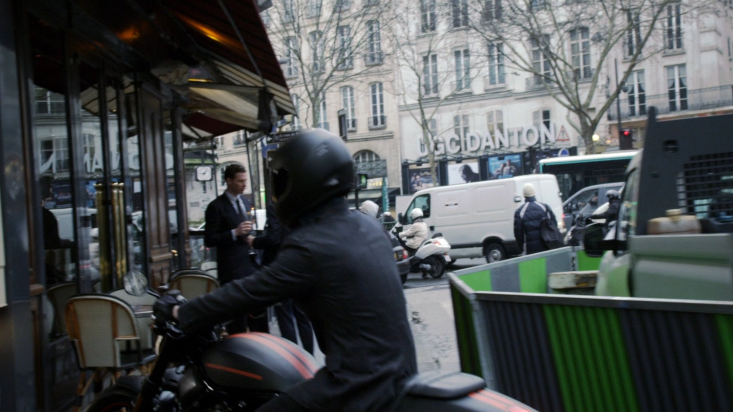 Motorcycle pulls up in front of Paris restaurant.