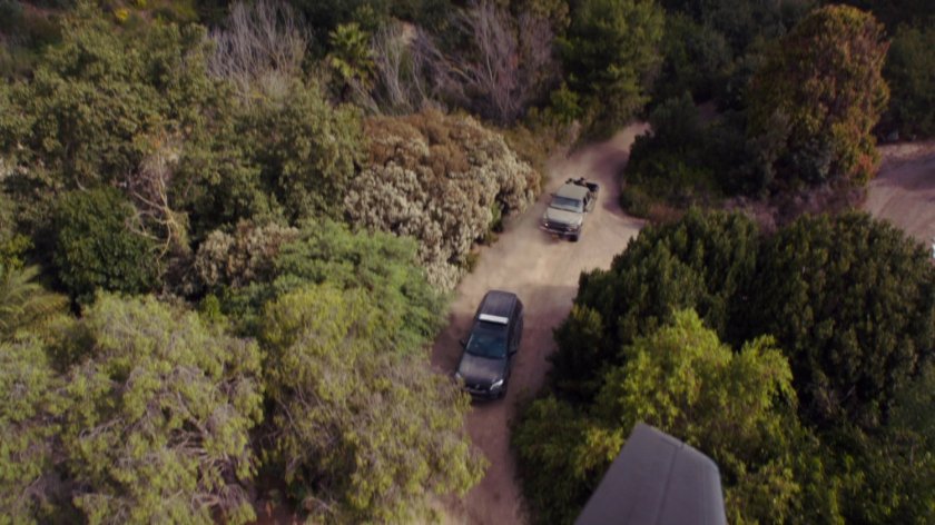 Aerial of trucks on Peruvian jungle road.