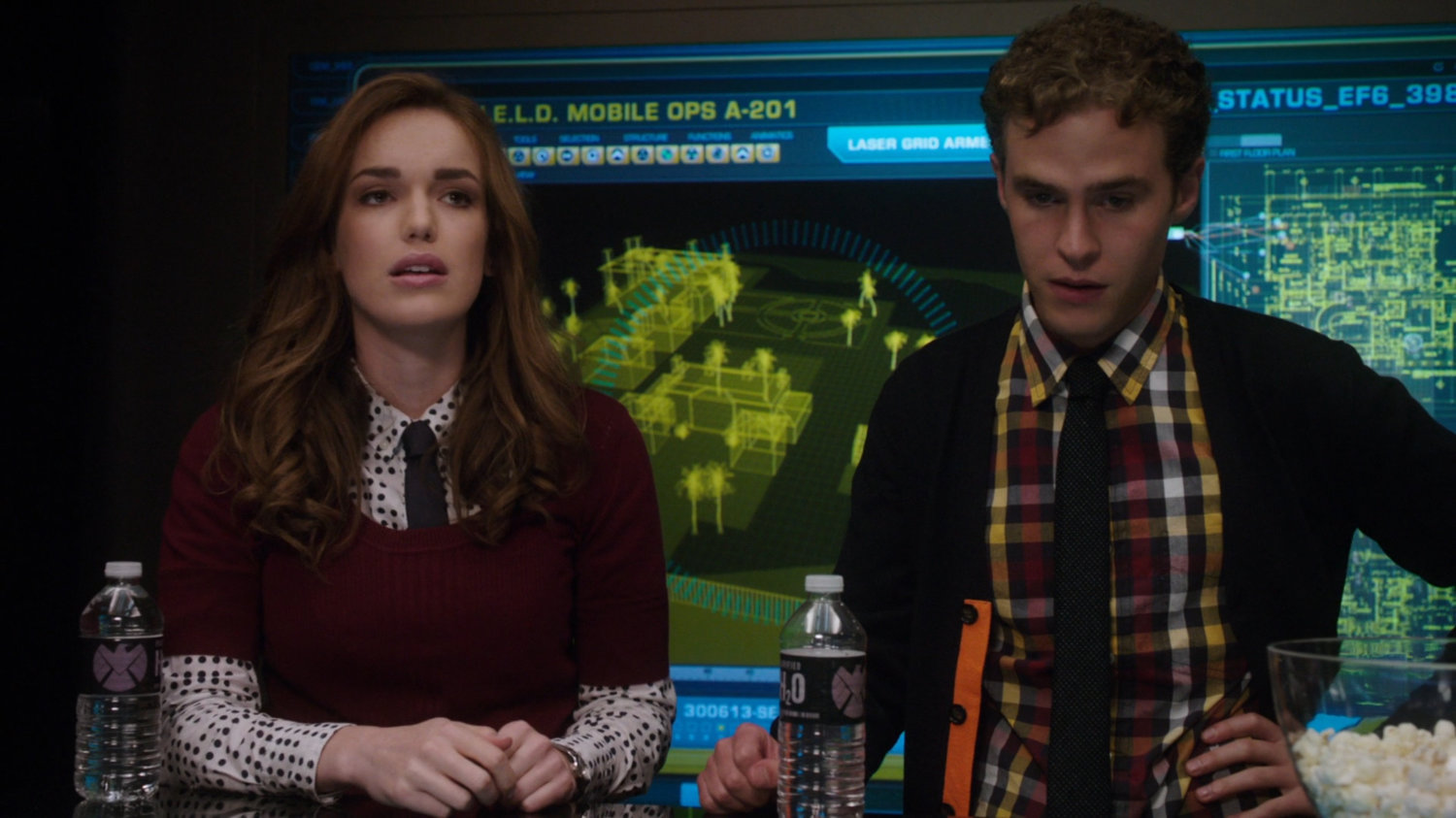 Simmons and Fitz with computer monitors behind them showing Ian Quinn's estate.