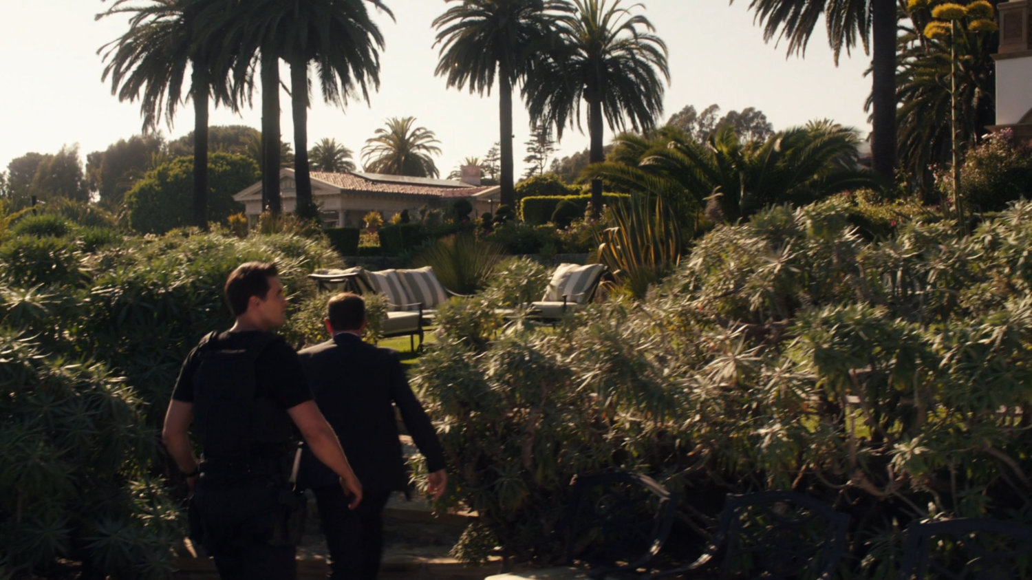 Coulson and Ward walk through plants surrounding Ian Quinn's estate.