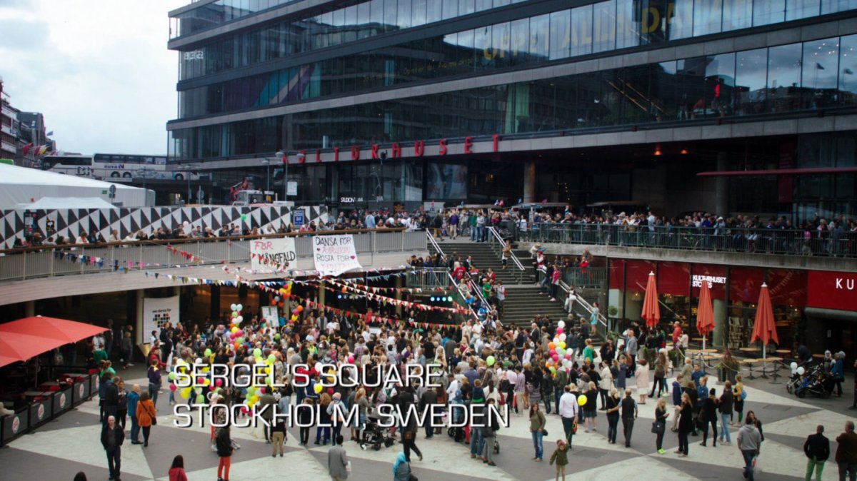 Crowds gather in the sunken plaza of Sergel's Square located in Stockholm Sweden. Text: Sergel's Square, Stockholm, Sweden