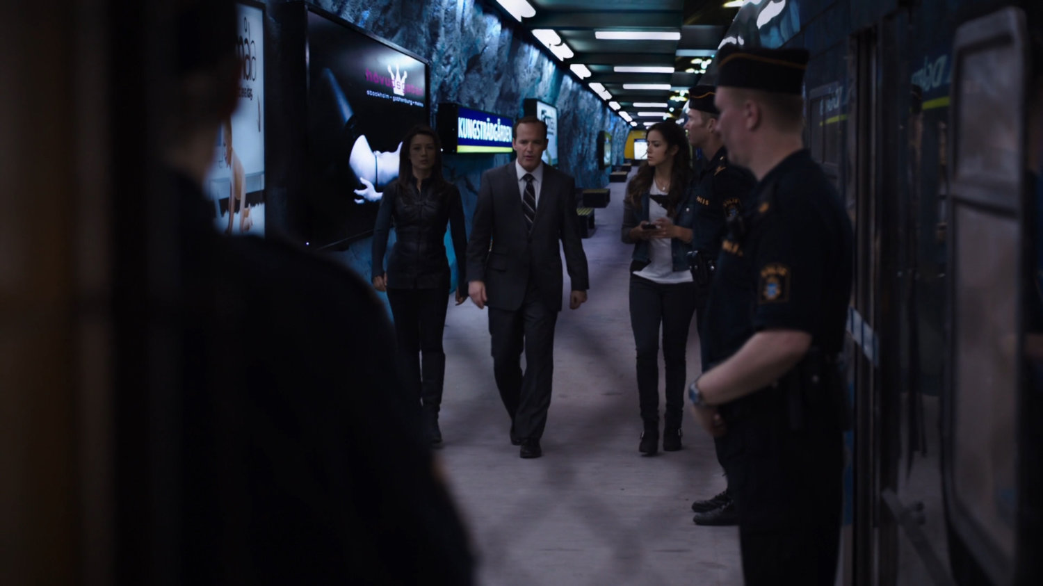 Agents May, Coulson, and Skye walk through the T-Centralen Metro.