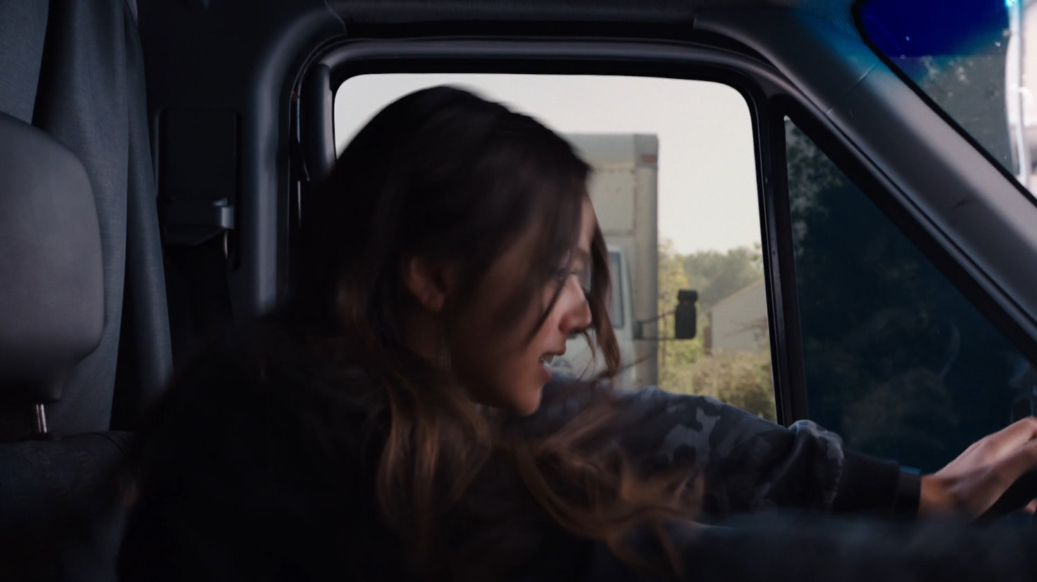 Skye in the driver's seat about to be rammed by a white truck.