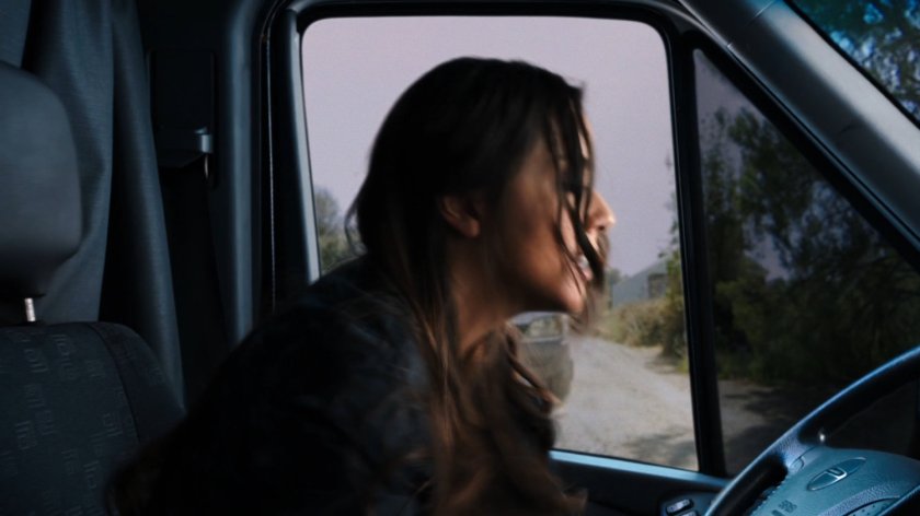 Skye in the driver's seat about to be rammed by a white truck.