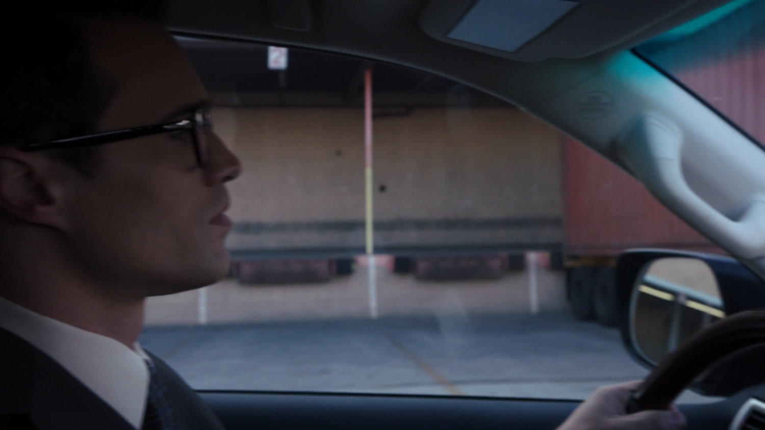 Agent Ward driving past a loading dock.