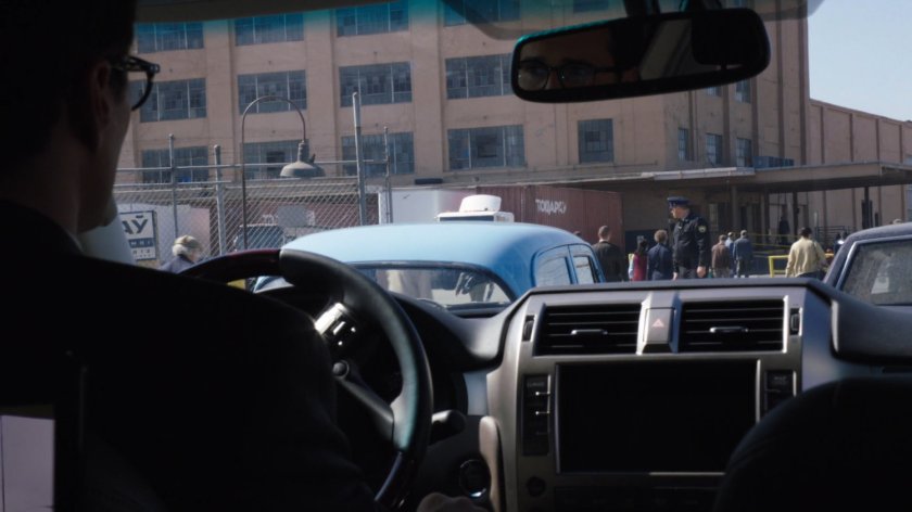 POV of Todorov Building and security guard from inside car.