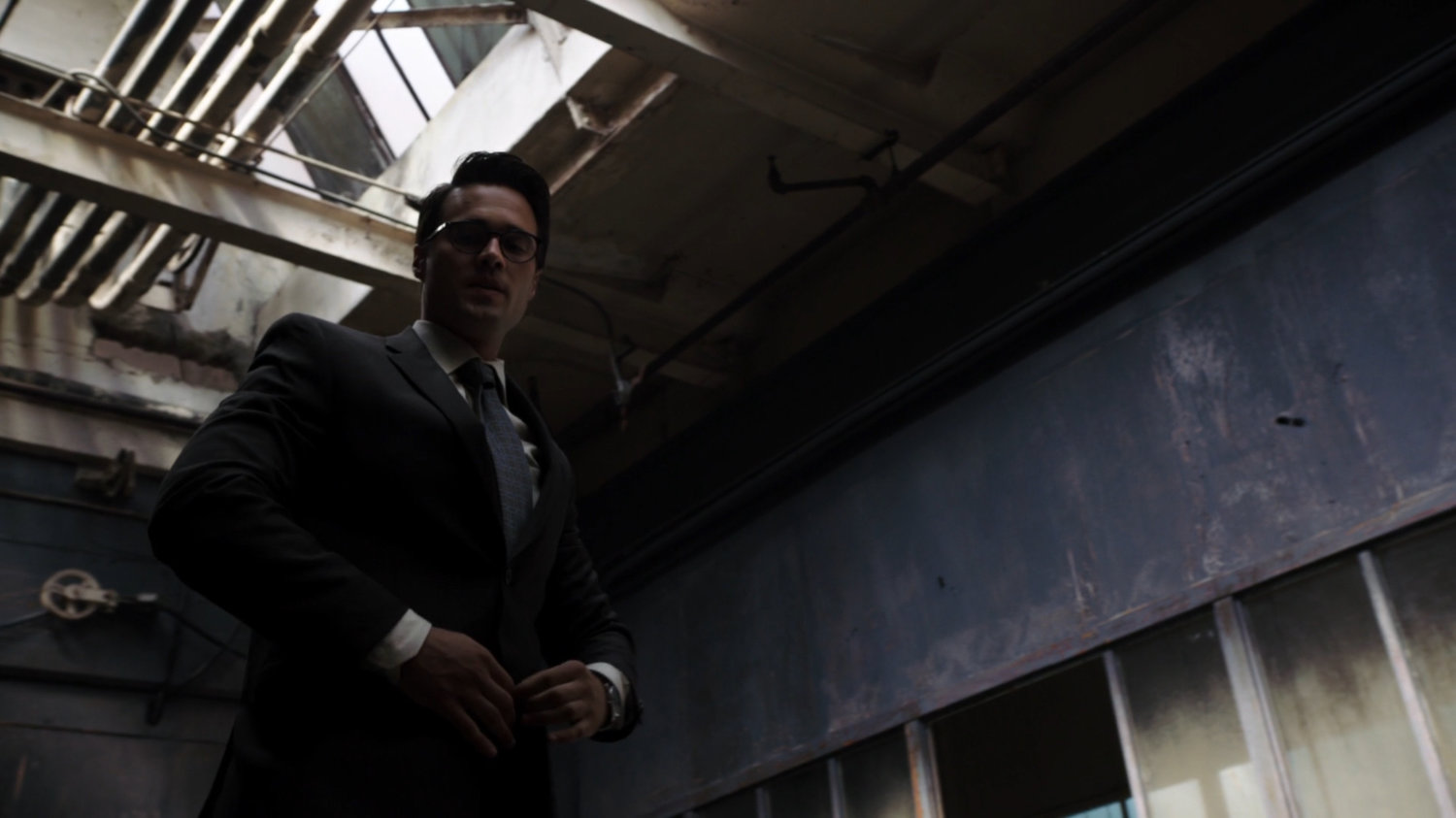 Low angle shot of Ward buttoning his jacket.