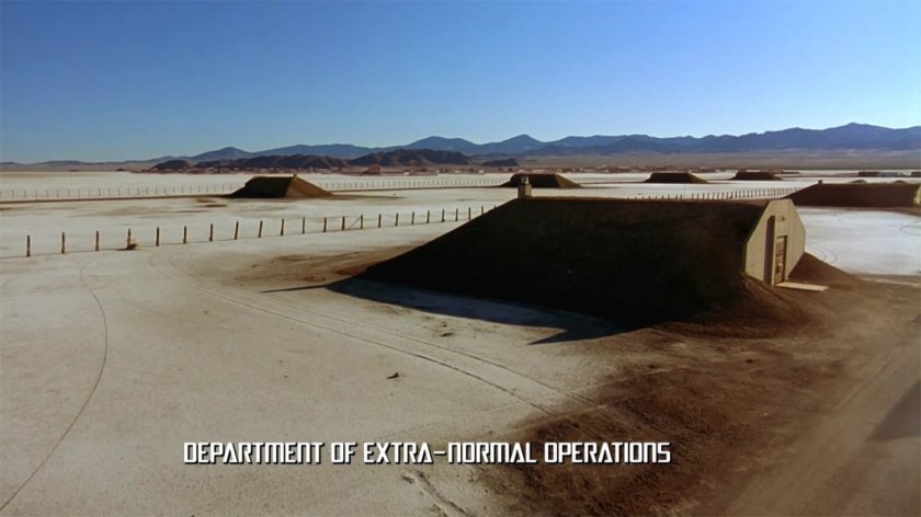 A desert munitions base. Text: Department of Extra-Normal Operations.