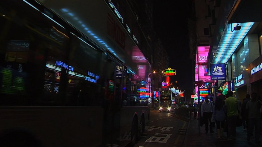 Nighttime Hong Kong street with neon lights.