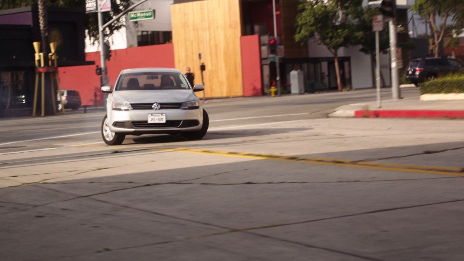 Grey car makes a sharp left on Austin street.