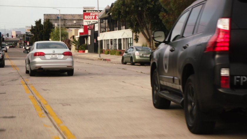 SHIELD SUV following grey car on Austin street.