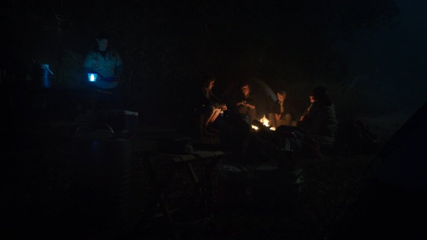 At night, a group of Ranger Scouts sits around a campfire.