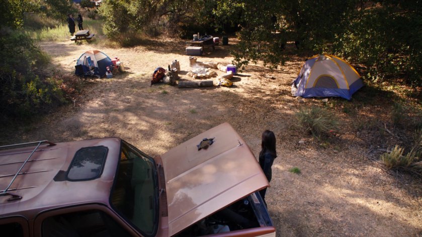 SHIELD Agents inspect a Ranger Scout camp in the morning, including a hole in the hood of a pickup truck.