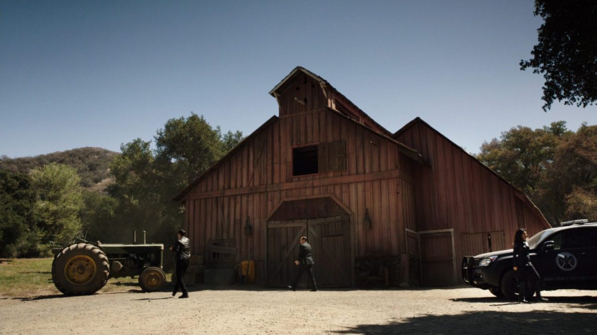 SHIELD Agents walk towards old barn.