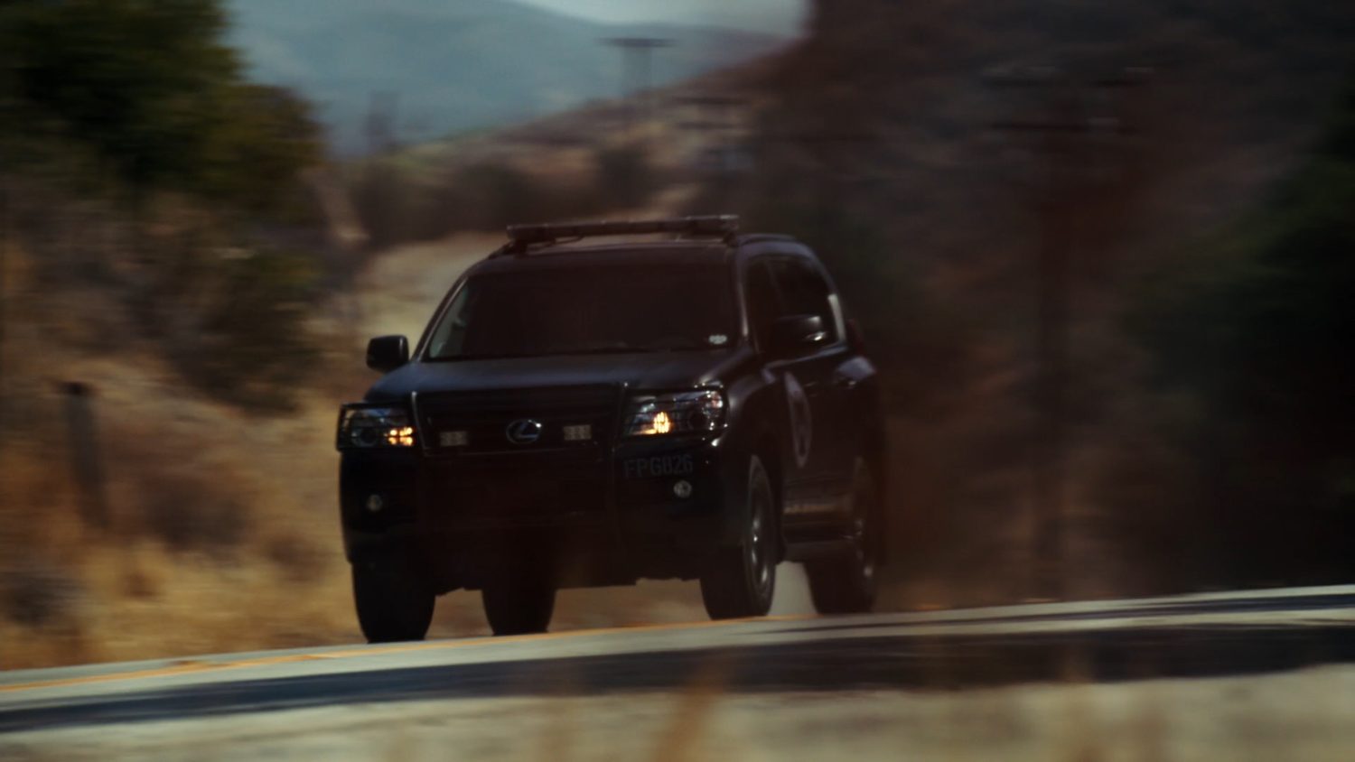 A SHIELD SUV racing along a rural road.