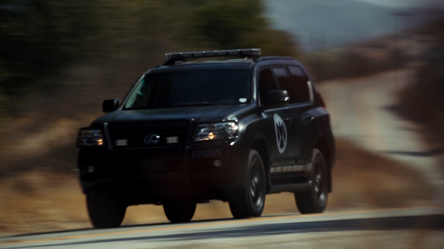 A SHIELD SUV racing along a rural road.