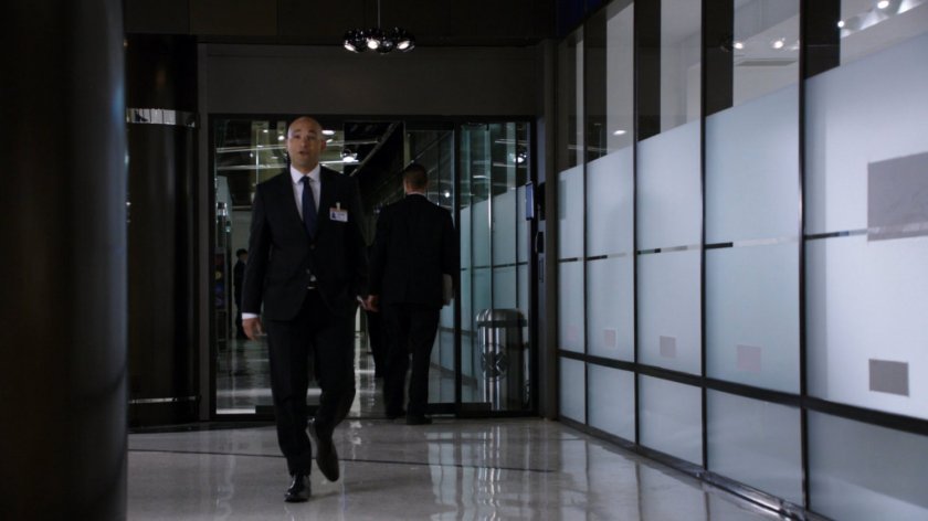 Agent Sitwell walking down a smaller hallway in the Hub.