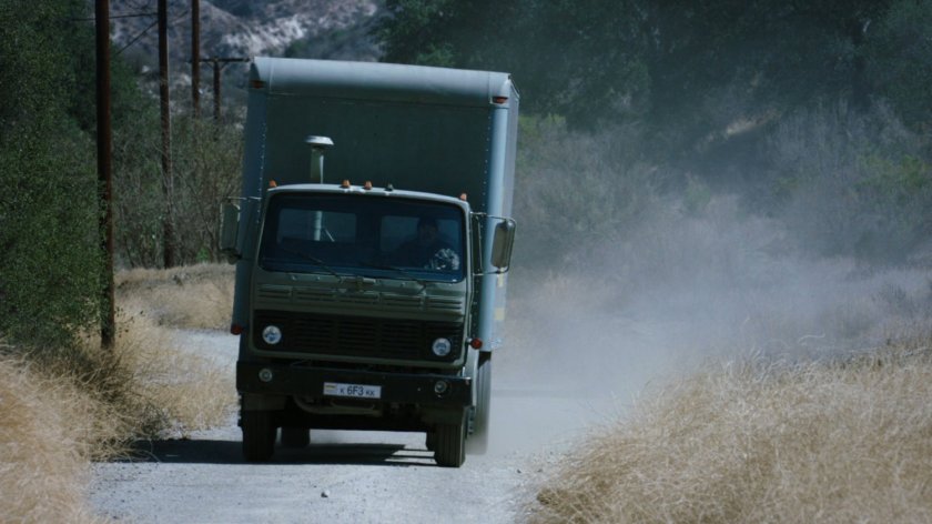 A military truck on a dusty Caucasus Mountain road.