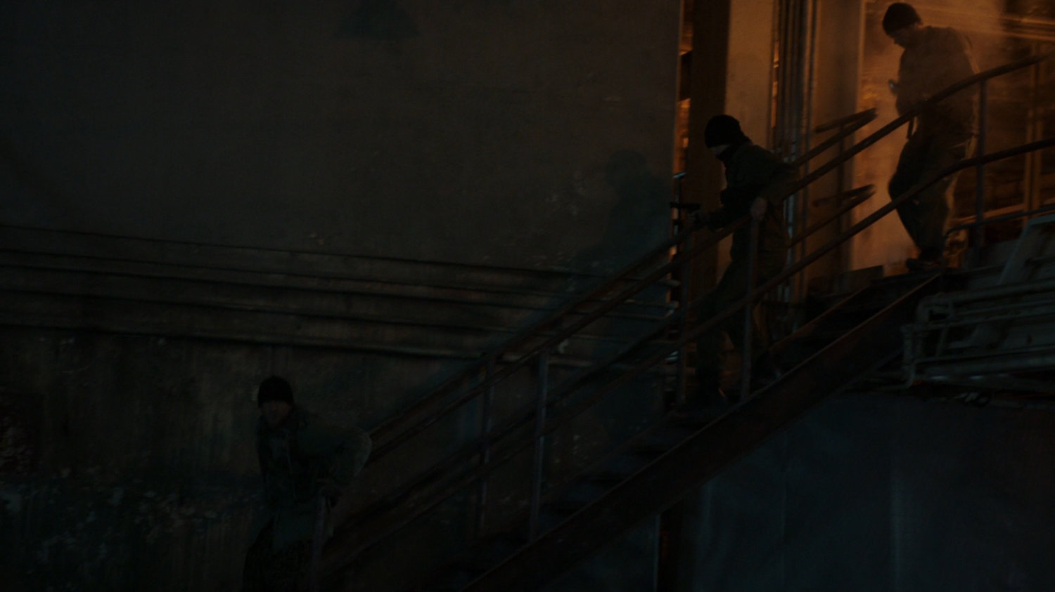 Two guards run down stairs in a Georgian power plant.