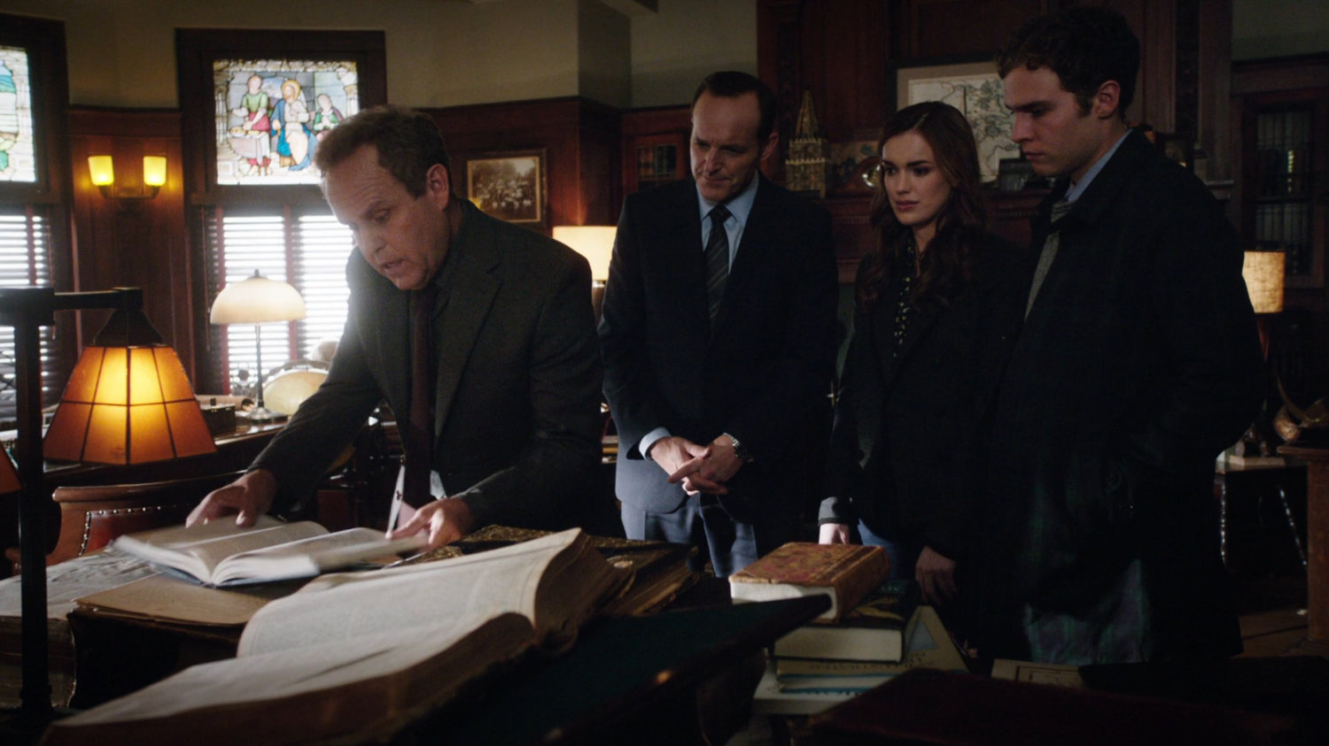 Professor Randolph shows the SHIELD Agents a book in his office.