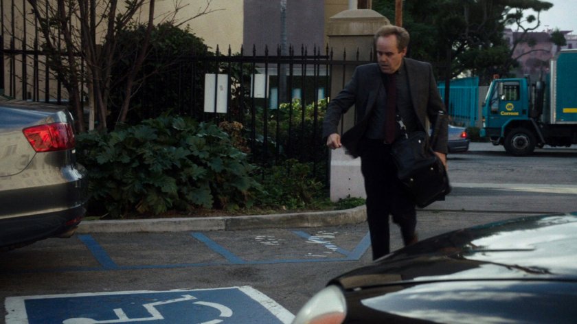 Professor Randolph hurries through a parking lot.