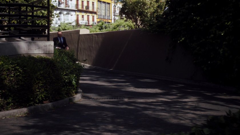 Coulson runs down driveway on the side of University building.