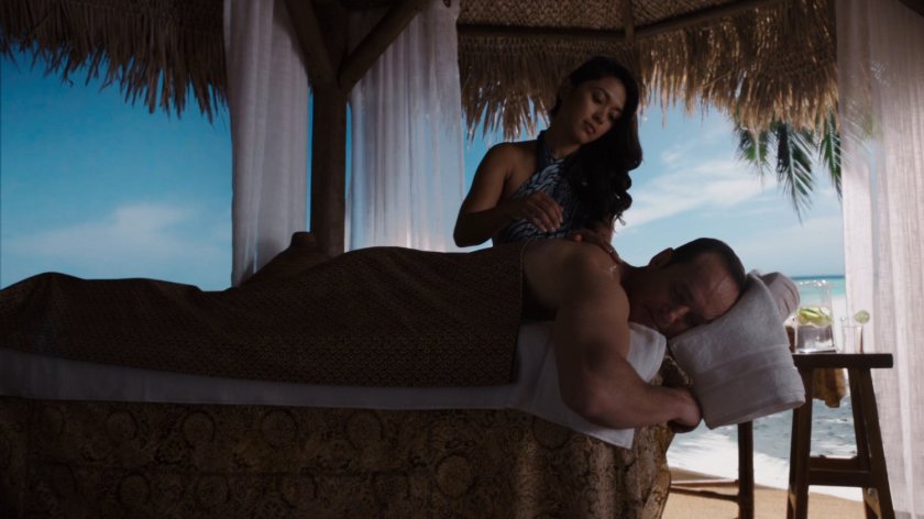 Coulson receiving massage from woman in Tahiti hut.