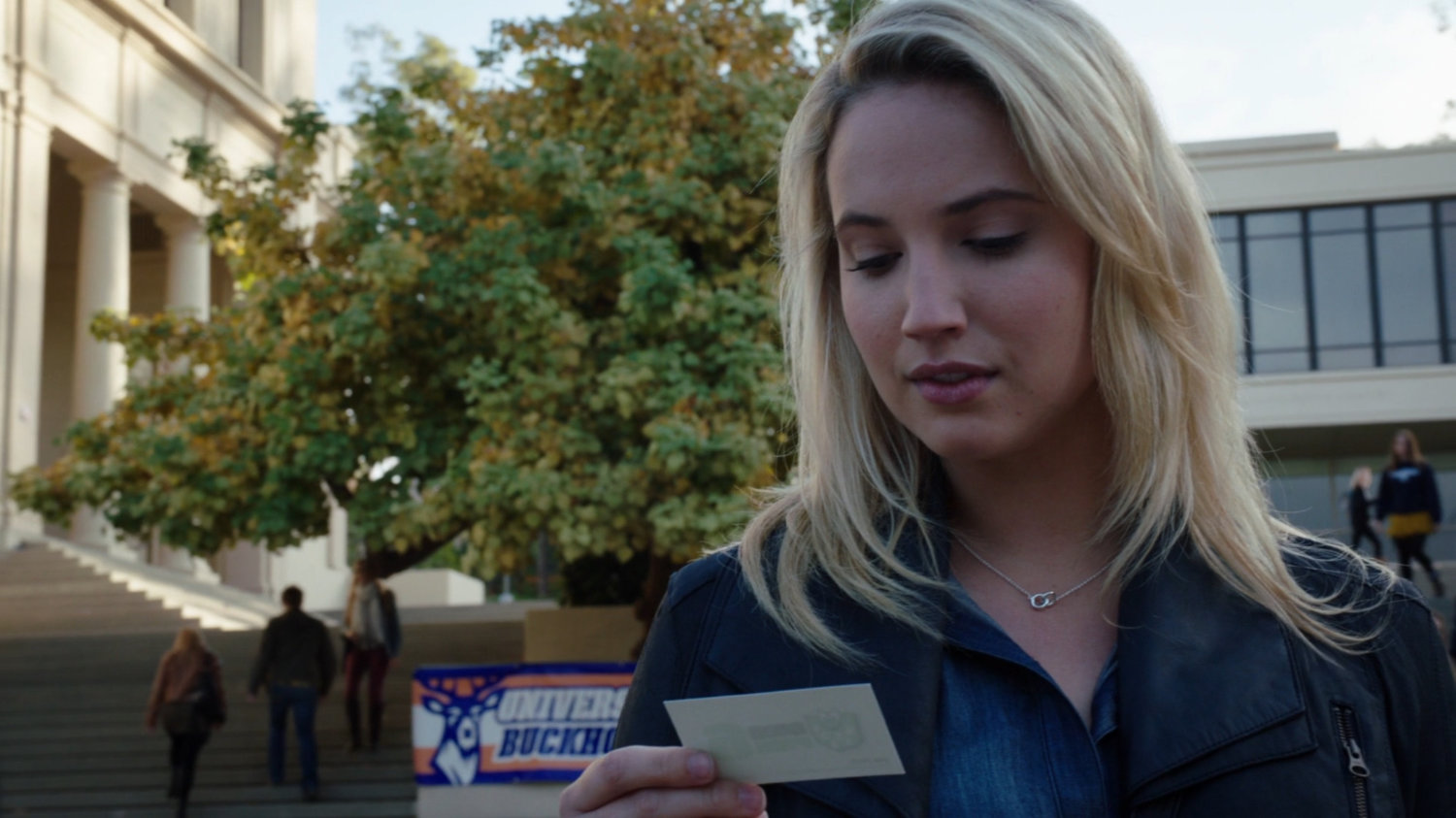 Laura Hayward looking at business card on the campus of the University of Ohio.