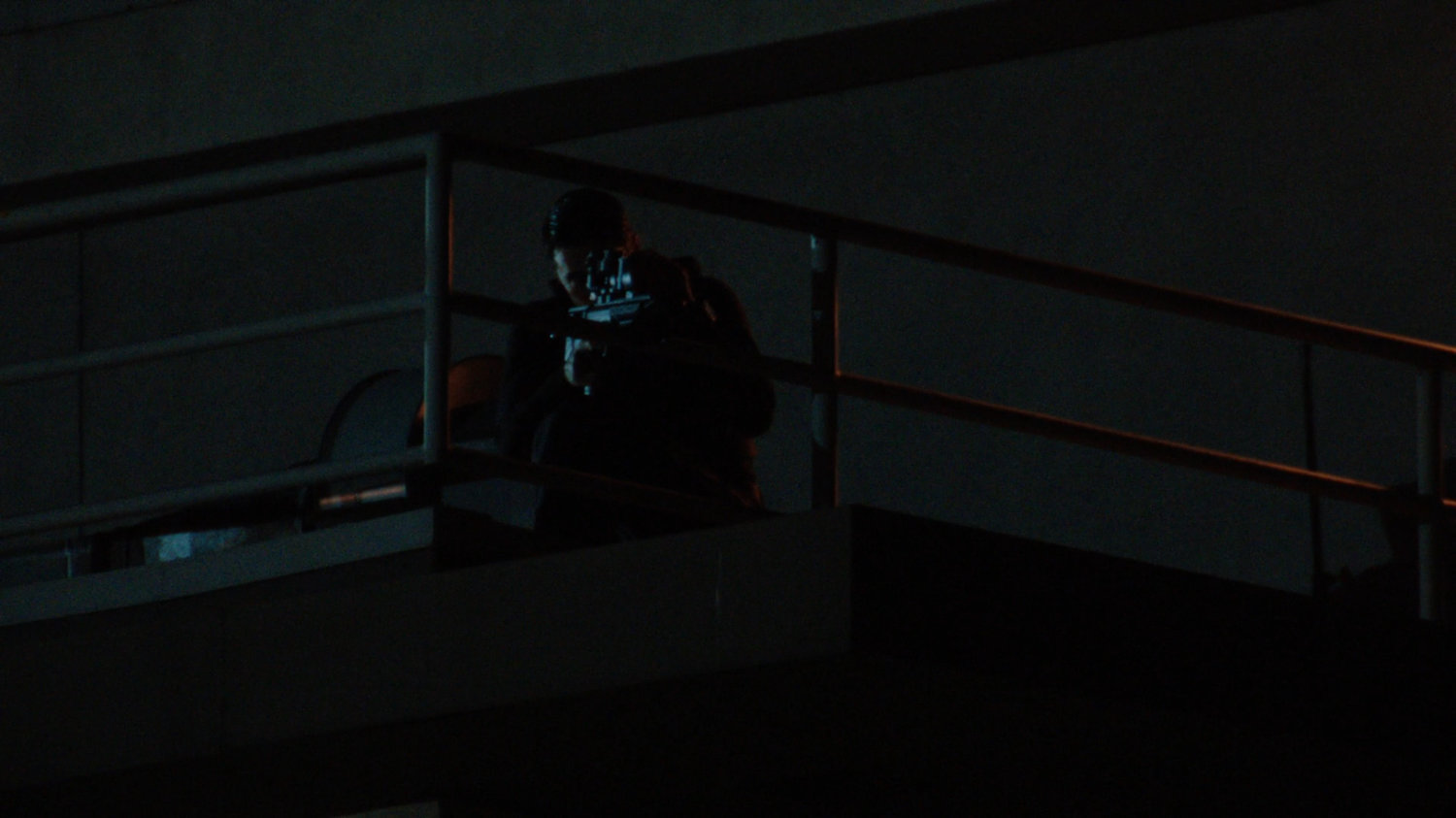 Nighttime shot of sniper on catwalk.