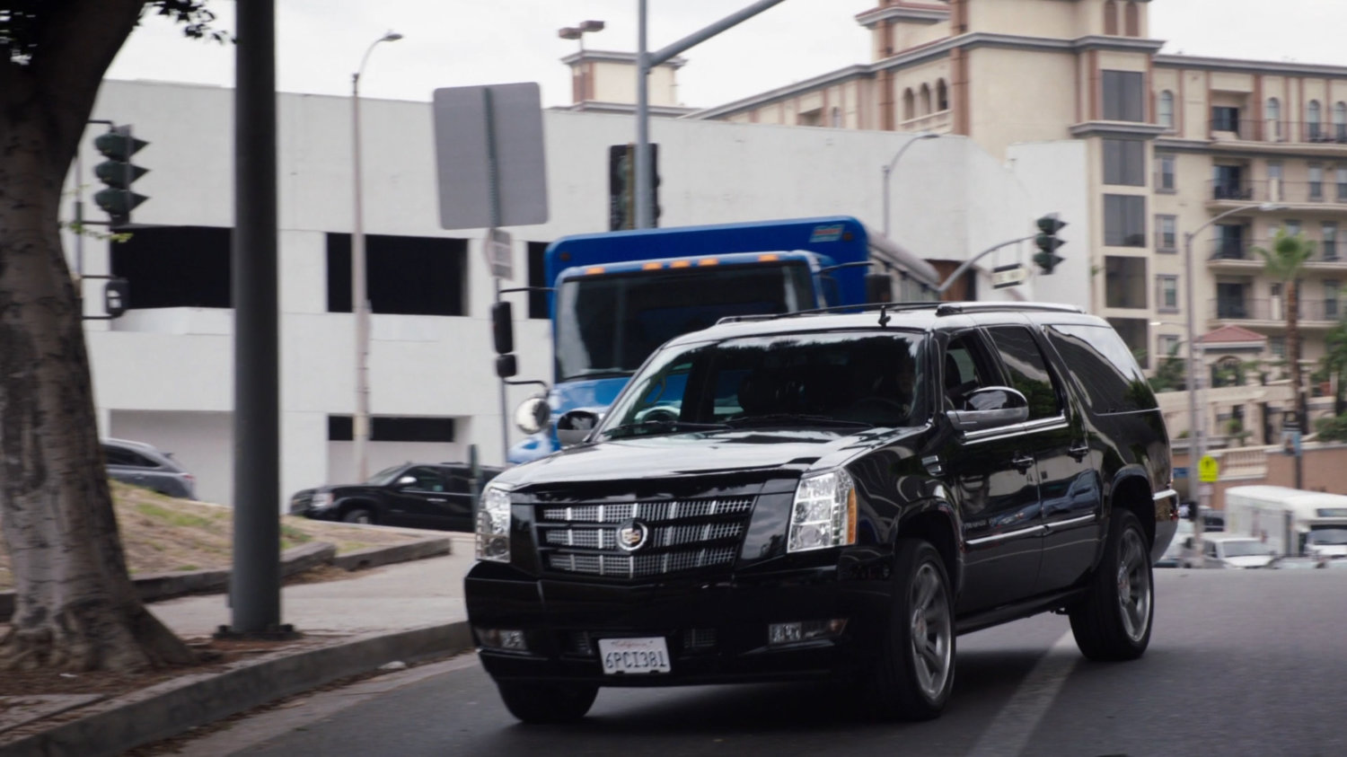 A black SUV pulls over to the side of the street.