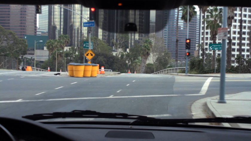 POV of Los Angeles intersection with yellow crash barrels.