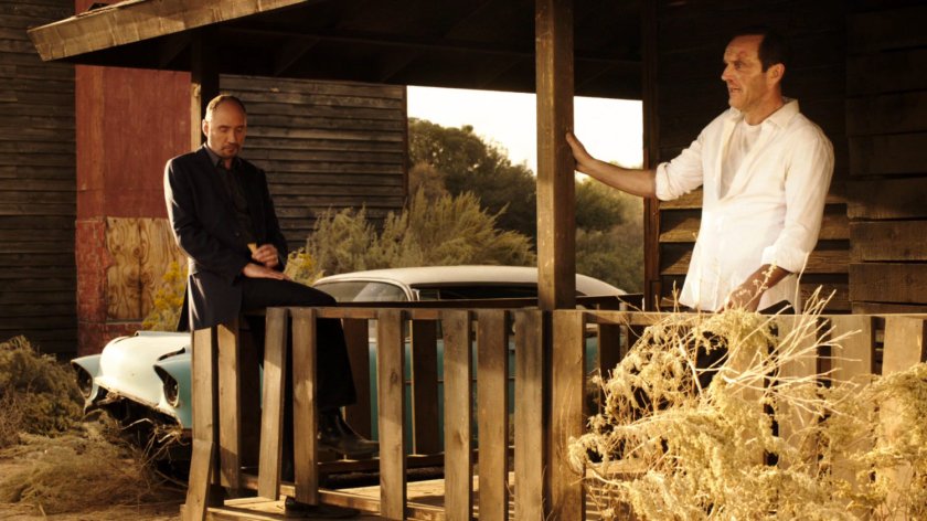 Edison Po and Coulson on the porch of an old building in an atomic ghost town.