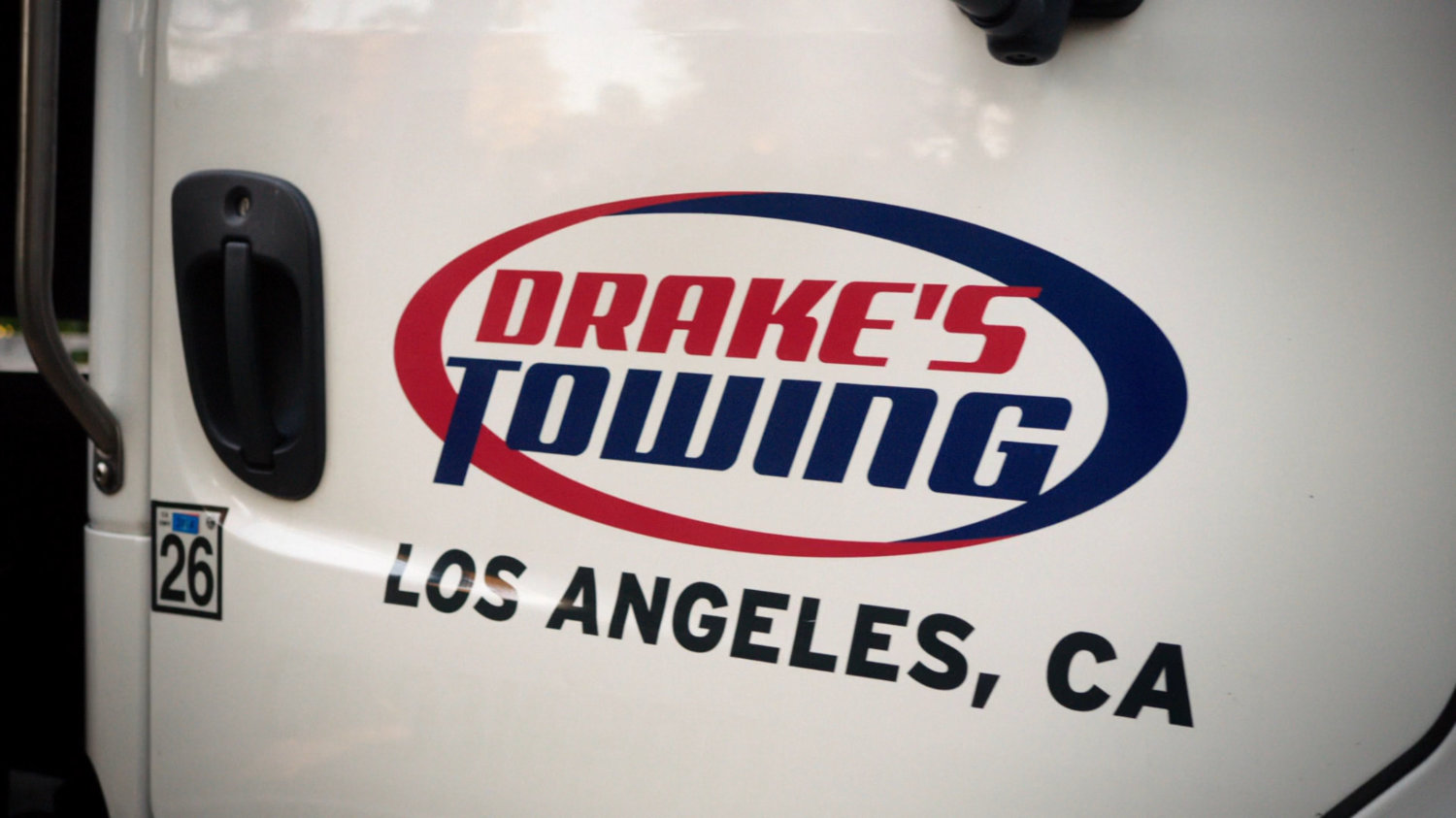 Close-up of Drake's Towing sign on door of truck.