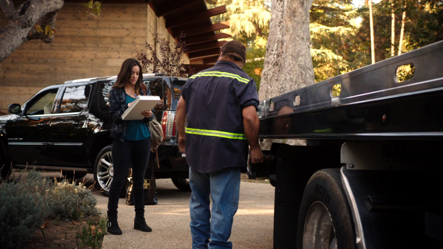 Skye in front of Lloyd Rathman's house with a tow truck driver.