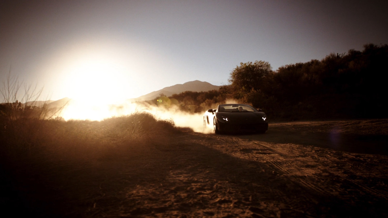 Skye in a sports car on dusty road.
