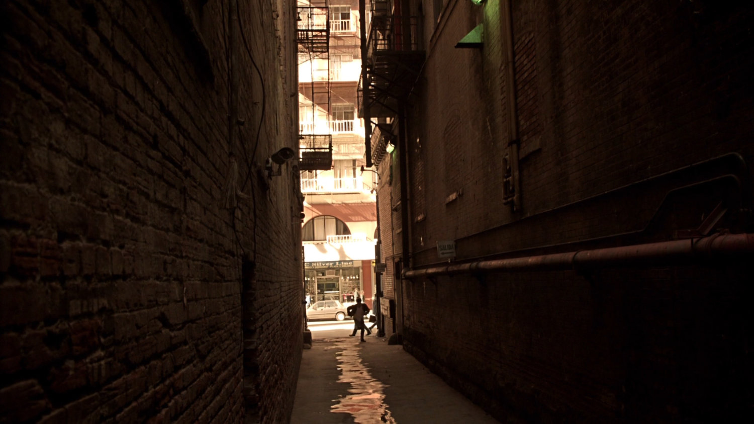 Agent Lumley runs through a narrow Mexico City alley.