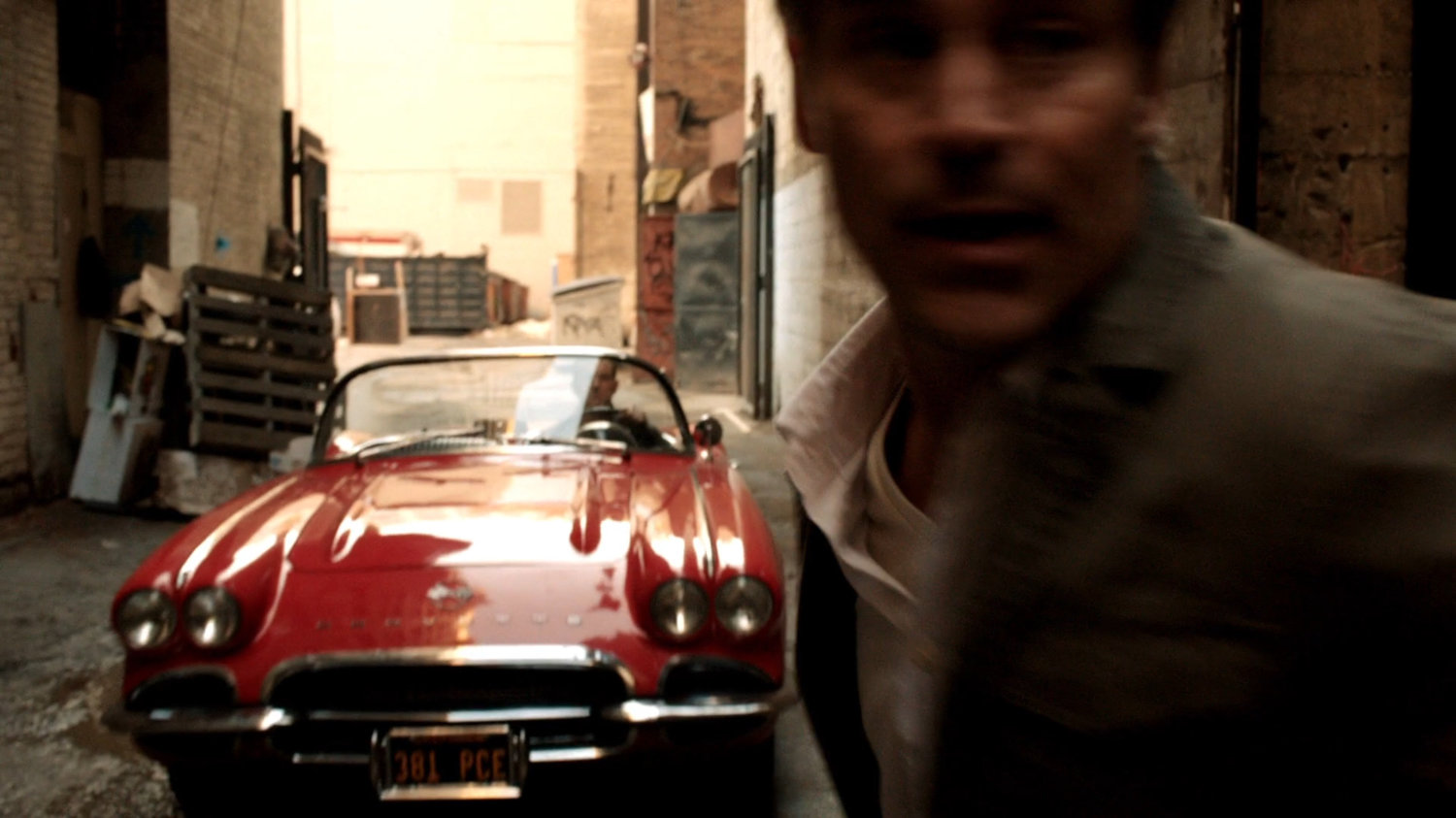 Coulson pulls into alley in Lola to block Agent Lumley's escape.