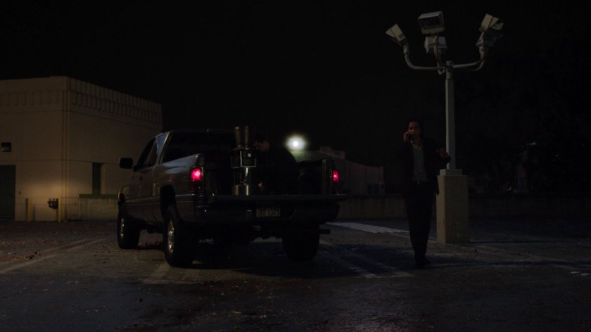 Seth on the phone next to a pickup truck on a parking deck.